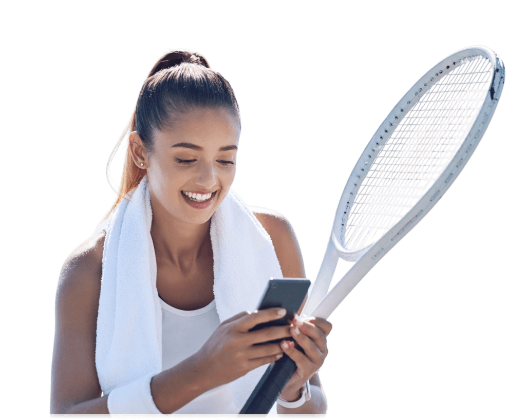 Woman with a tennis racket and towel, smiling at her phone.