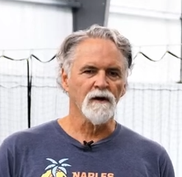 Man with gray hair and beard wearing a Naples Beach t-shirt