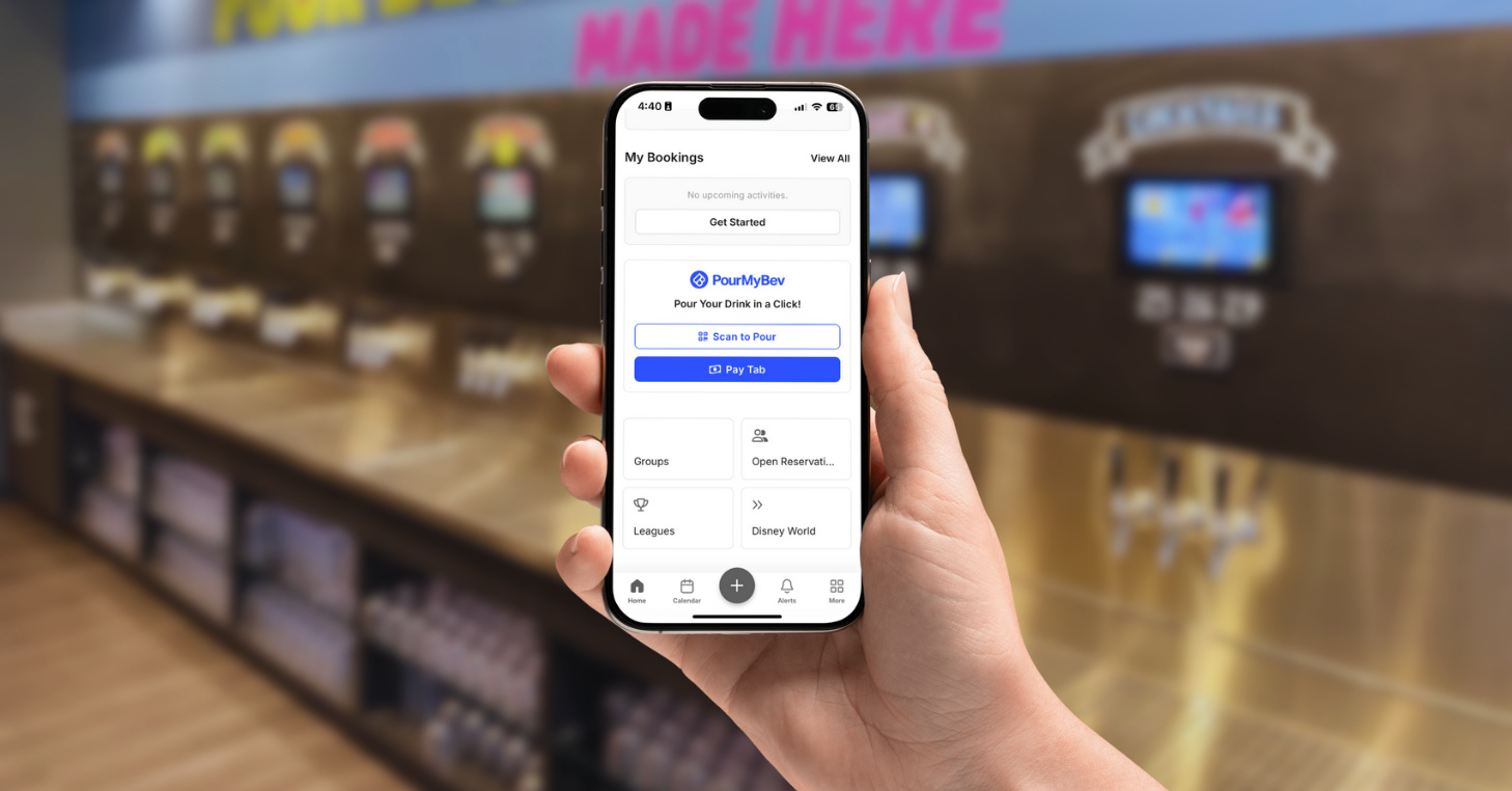 A person holds a smartphone showing the CourtReserve app with a highlighted PourMyBev integration, featuring options to “Scan to Pour” and “Pay Tab.” The blurred background displays a modern self-pour beverage station with multiple drink taps, emphasizing seamless beverage access within a club environment.