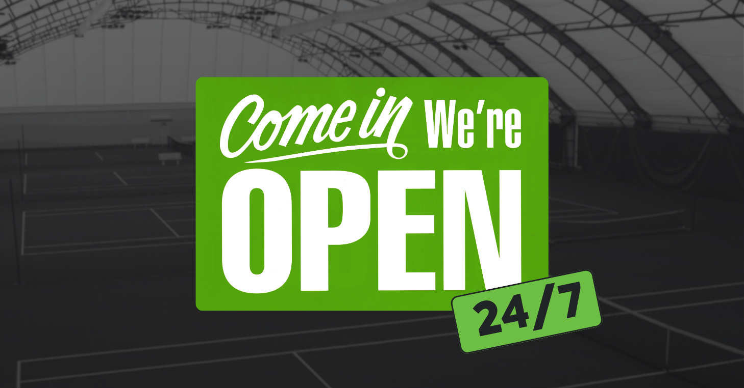 247 Facility 1 Green sign with bold white text that says ‘Come in, We’re OPEN’ with an additional green tag reading ‘24/7,’ overlaid on a background of indoor tennis courts.